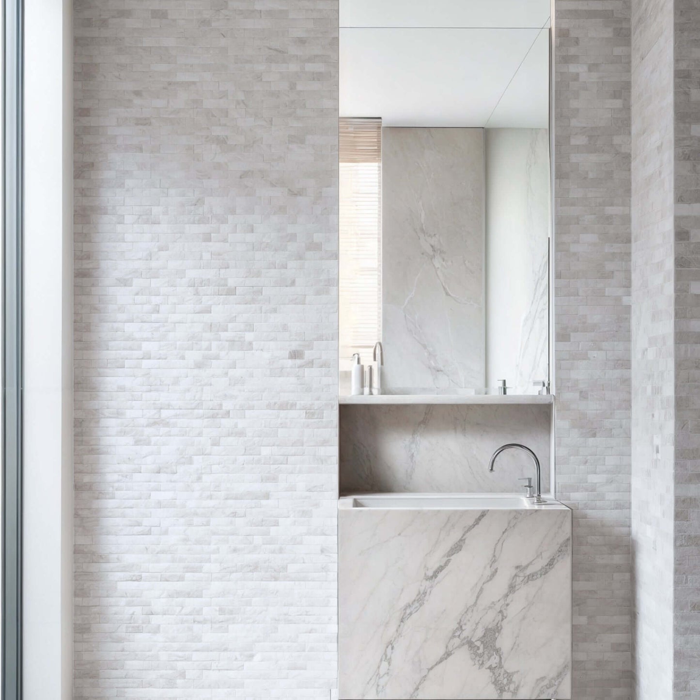 Stylish bathroom featuring Limestone Blasted Mosaic on walls and a marble vessel sink with polished finish.