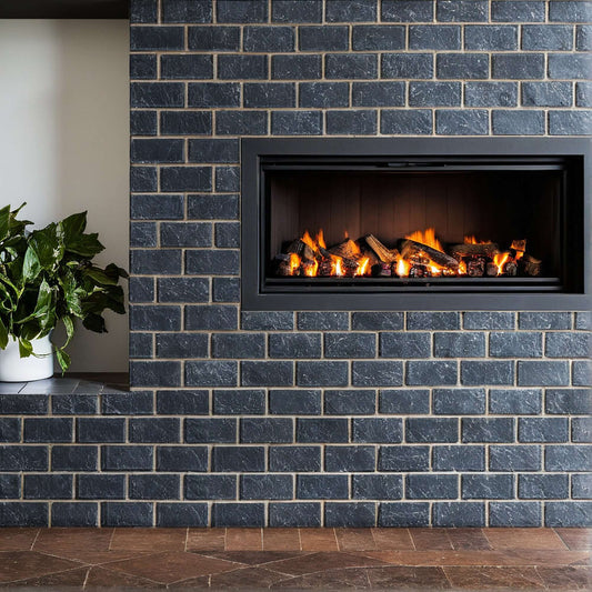 Modern fireplace with a sleek black stone surround and logs, accentuated by greenery in a minimalist design.