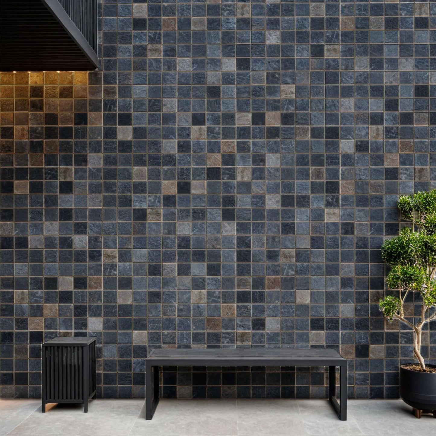 Stylish black marble mosaic wall with natural texture, complemented by a modern wooden bench and greenery.