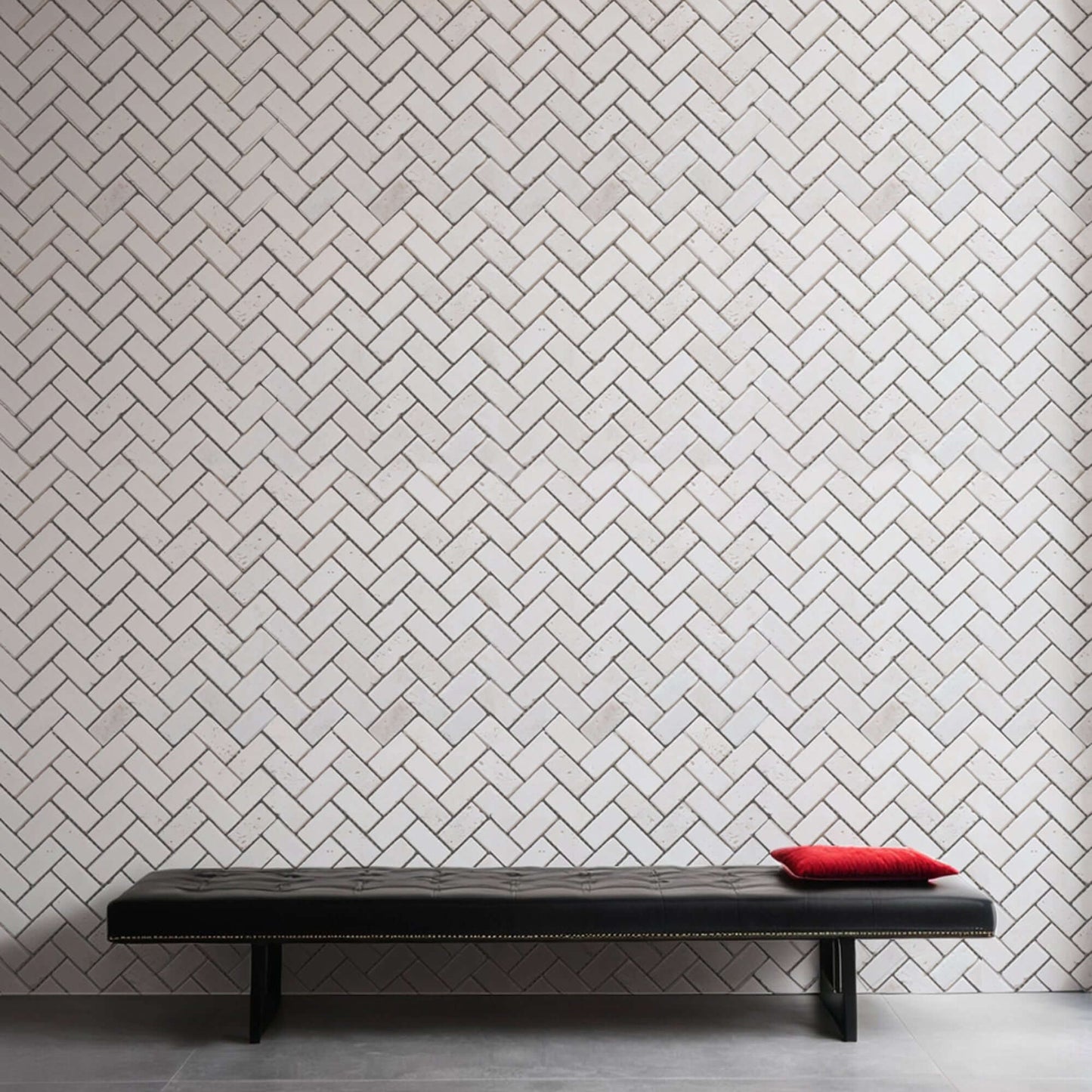 Minimalist design featuring a herringbone-patterned wall made of premium natural stone with a sleek black bench.