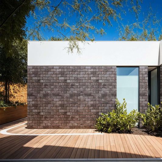 Exterior view of a modern building featuring natural stone wall, complemented by wooden deck and greenery.