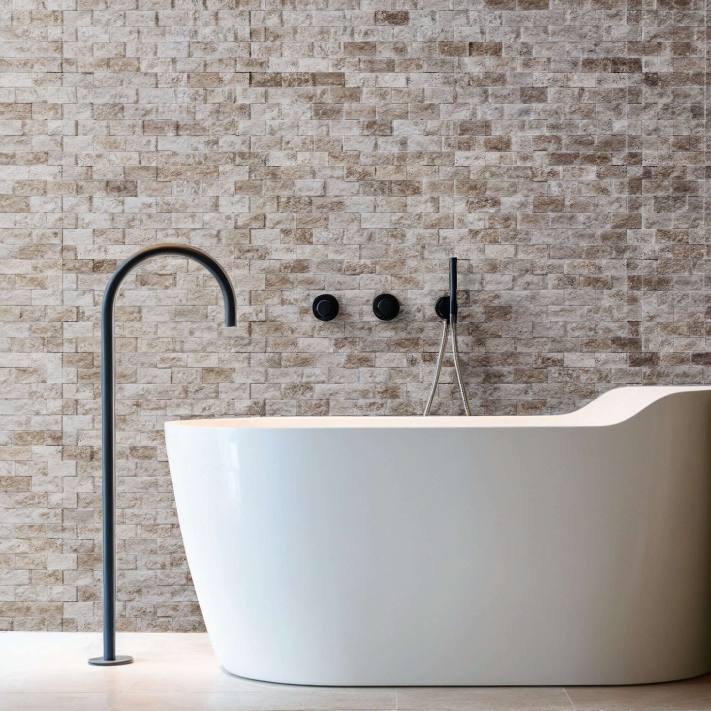 Elegant bathroom featuring a freestanding tub and light travertine blasted stone wall design.