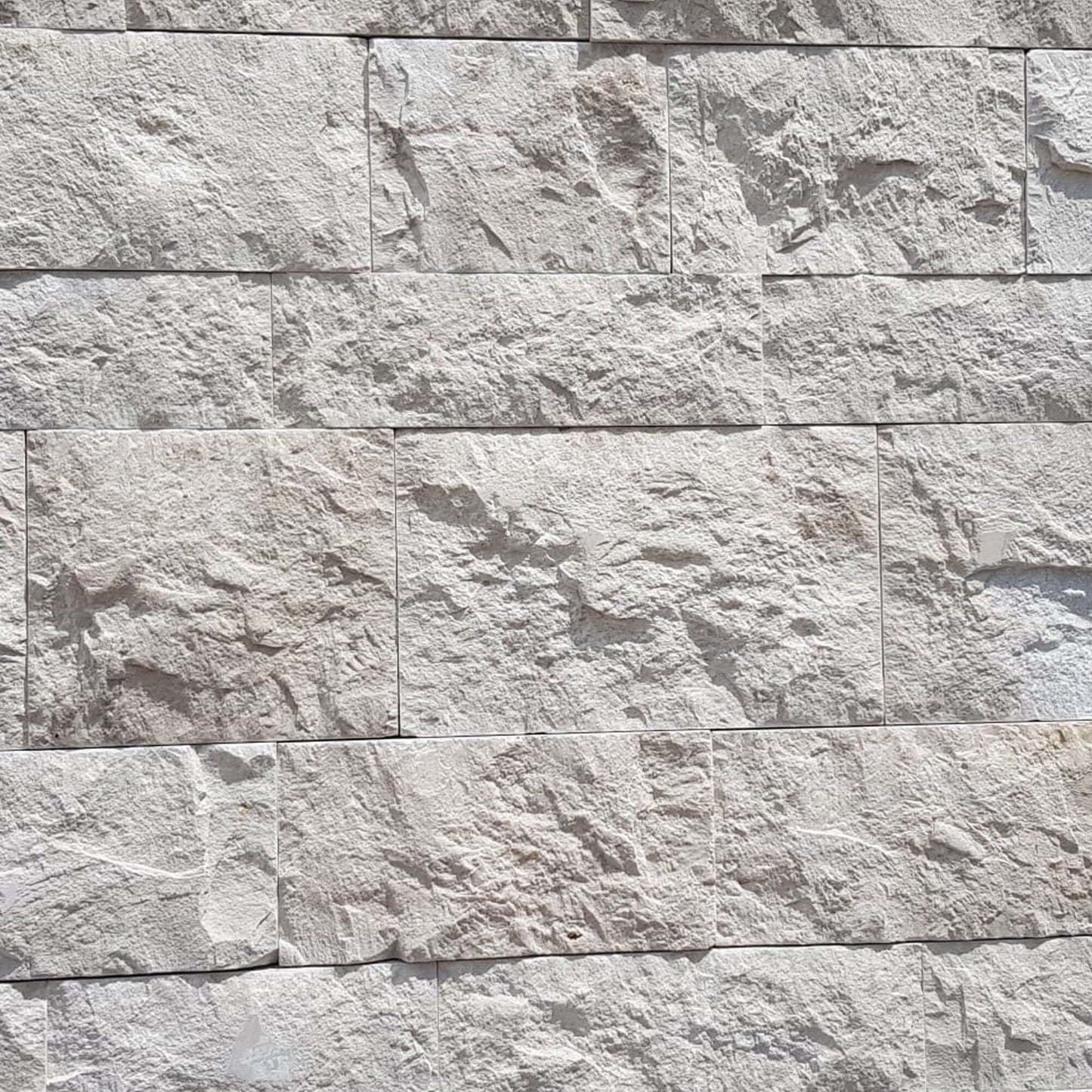 Textured travertine mosaic wall featuring premium stones with a natural finish, ideal for minimalist designs.