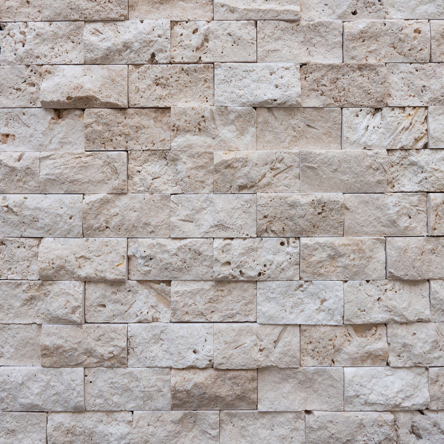 Blasted travertine wall tiles showcasing natural stone's elegant 3D texture, ideal for minimalist designs and vessel sinks.