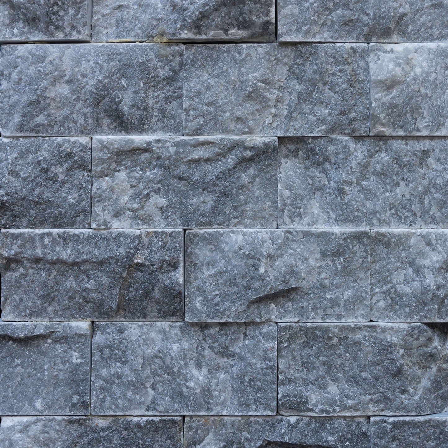 Blasted marble mosaic brick wall design, showcasing premium natural stone craftsmanship and minimalist elegance.