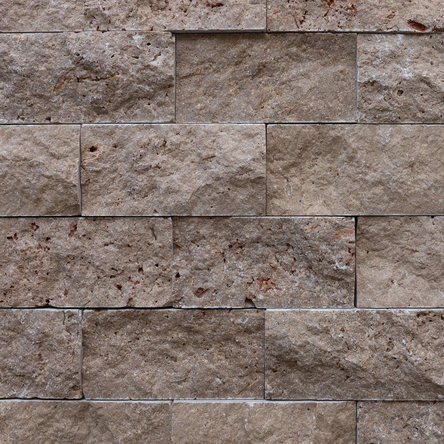 Blasted travertine brick mosaic displaying a textured, natural stone surface for premium design and lasting elegance.