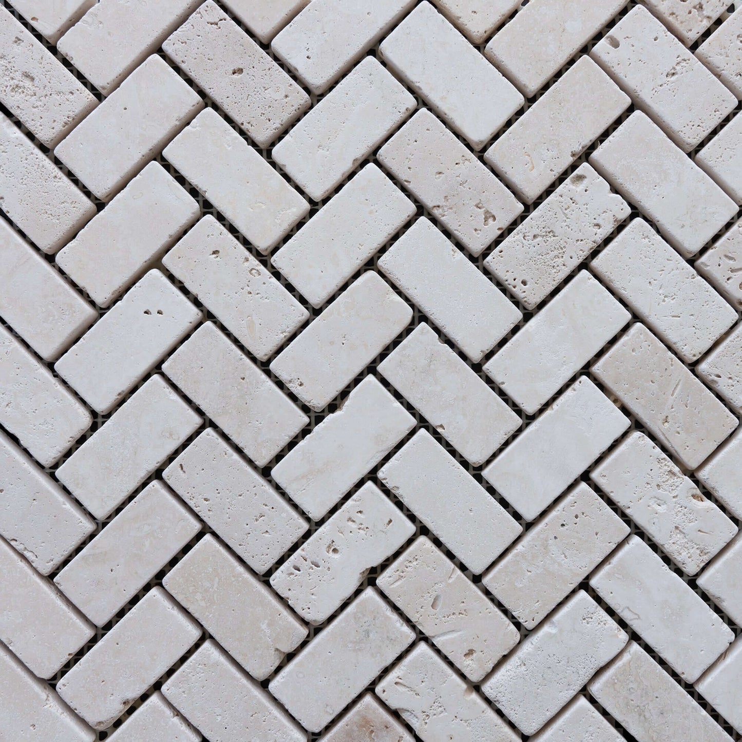 Travertine distressed mosaic tiles in a herringbone pattern, showcasing premium natural stone craftsmanship.