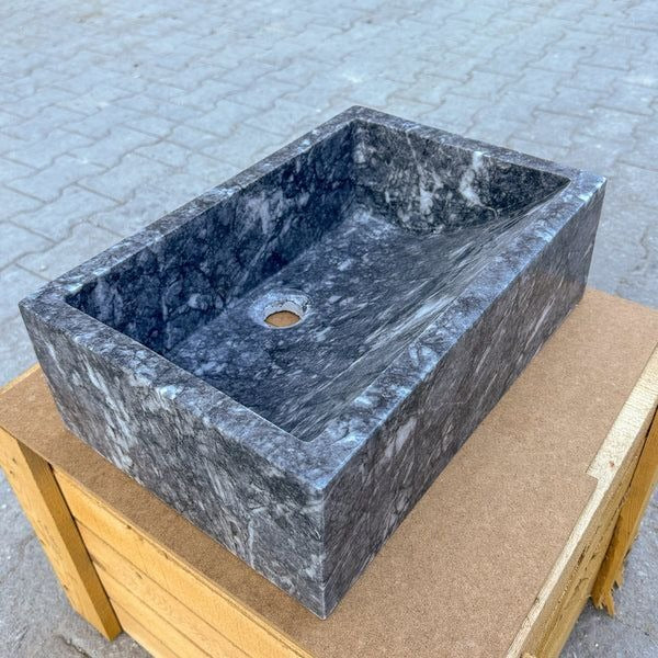Elegant grey marble vessel sink with polished finish, featuring minimalist design and soft veining.