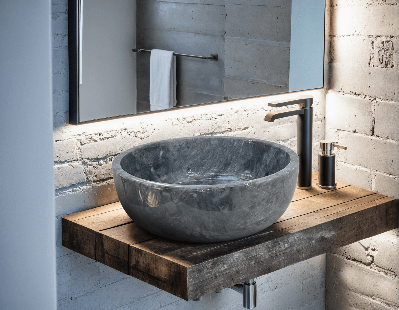 Polished dark grey marble vessel sink on a wooden countertop, showcasing minimalist design and natural stone elegance.