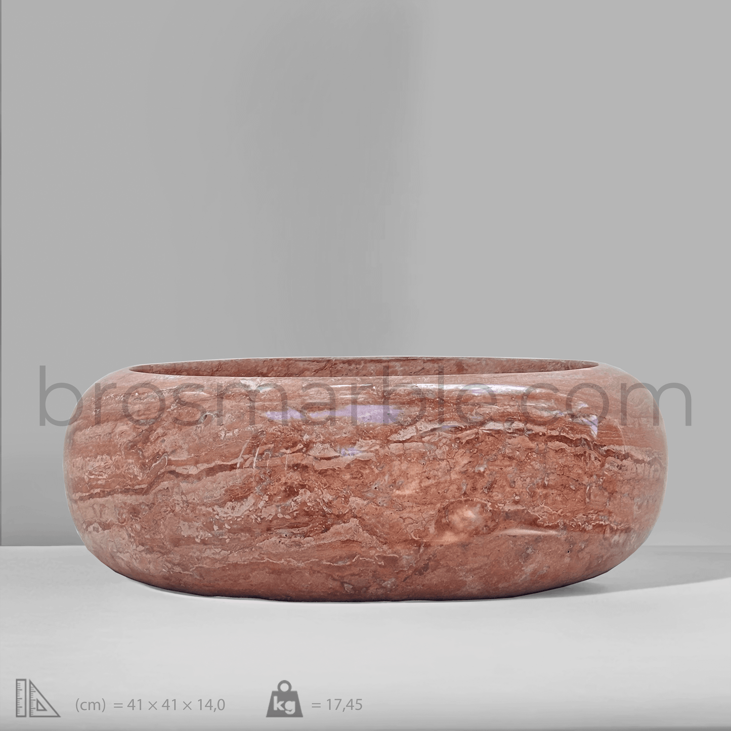 Handcrafted red travertine vessel sink with a polished finish, showcasing minimalist design and unique natural stone qualities.