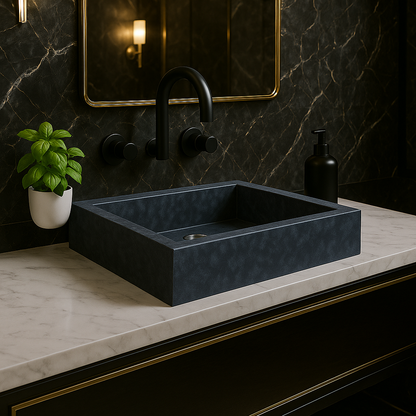 Black rectangular sink on a marble countertop with a dark marble wall and mirror.