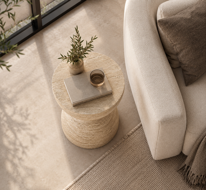 Duo Travertine Side Table styled beside a sofa in a luxury contemporary living room.