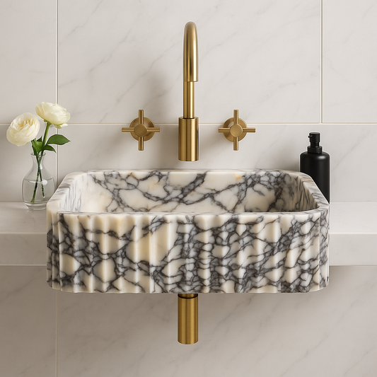 Calacatta Viola marble sink with gold faucet in modern bathroom setting, showcasing unique veining and elegant design.