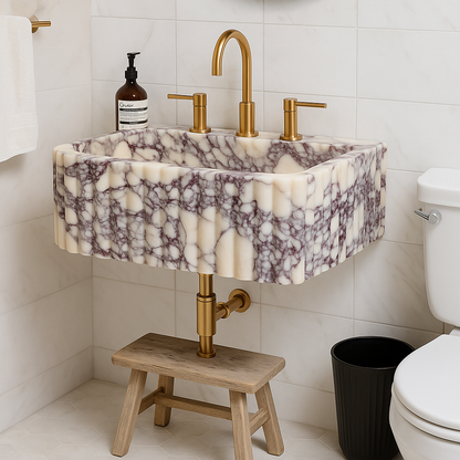 Calacatta Viola marble sink with rich purple veining, gold faucets, and a wooden stand in a modern bathroom setting.