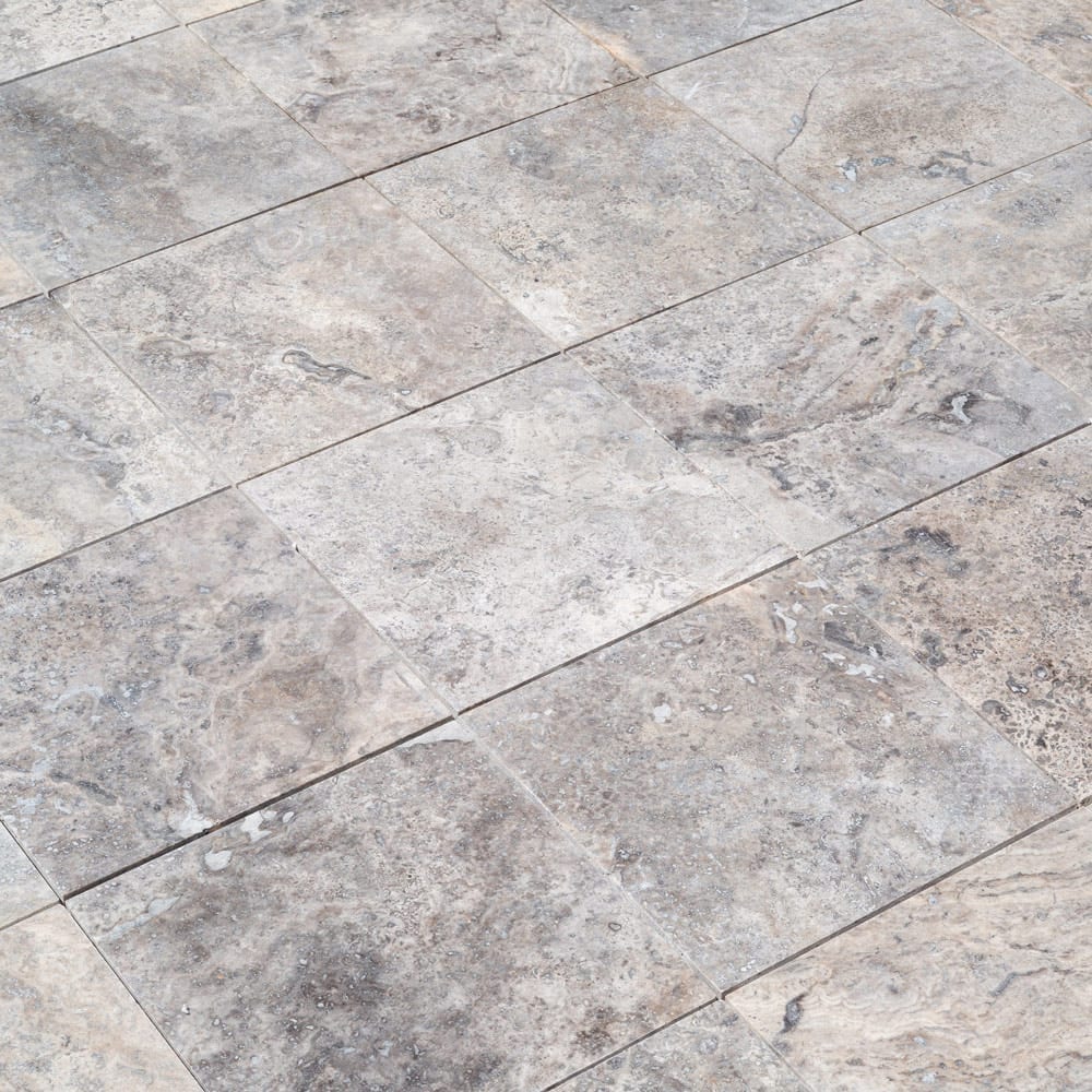 Elegant pewter vase displayed on a polished travertine surface, illustrating a blend of classic and modern decor.